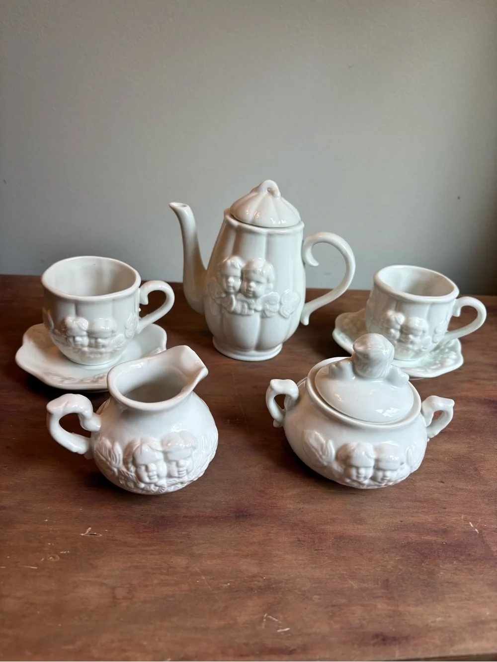 Vintage White Ceramic Mini Tea Set with Embossed Floral And Cherub Motif.